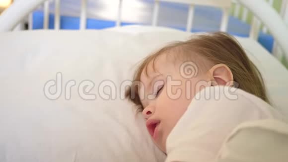 幼儿睡在医院病房的白色被褥上用温度计测量体温对儿童的治疗视频的预览图