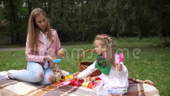 妈妈和女儿在一个秋天的公园里玩塑料玩具4k动作缓慢视频的预览图