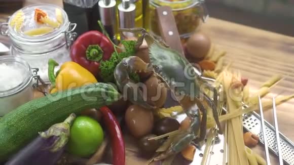 意大利餐厅有活蟹和新鲜蔬菜的食物背景生蔬菜和干面食中的活蟹视频的预览图