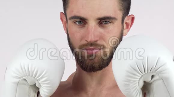 大胡子男拳击手对着镜头微笑站在战斗姿势视频的预览图