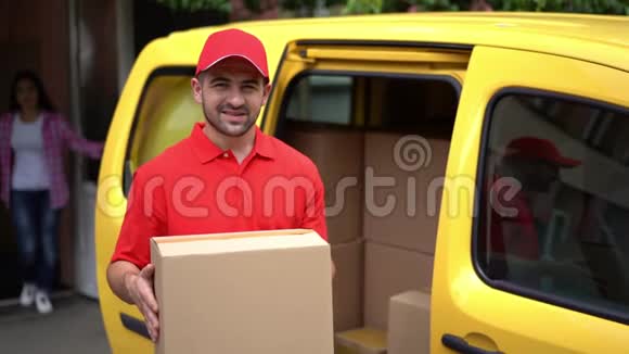 一个微笑的人从送货箱和站在黄色的车附近视频的预览图