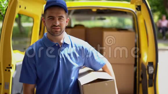 微笑快乐的快递员在敞开的货车门前送包裹并显示OK标志视频的预览图