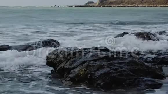 海上的风暴海岸上的波浪破碎海水的飞溅和岩石下的水的泡沫保加利亚黑海视频的预览图