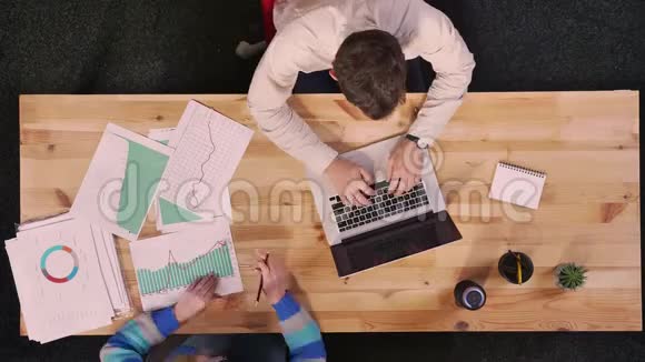 两位同事正在吃美味的披萨还在工作电脑木制的视频的预览图