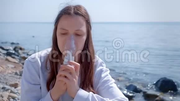 女性使用雾化吸入器面罩治疗海边纤维化哮喘视频的预览图