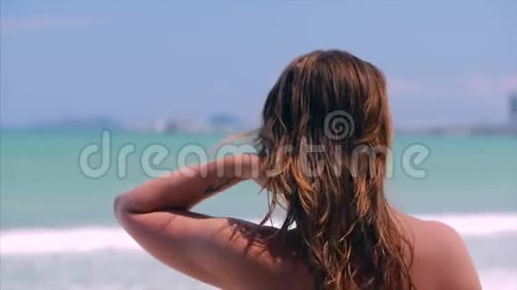 欧洲美丽的可爱的深褐色头发的年轻女子或开朗的女孩向大海奔去的特写镜头视频的预览图