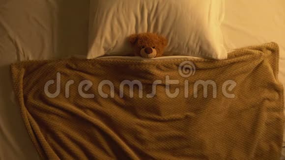 泰迪熊玩具躺在被毯子覆盖的床上童年的回忆纯真视频的预览图