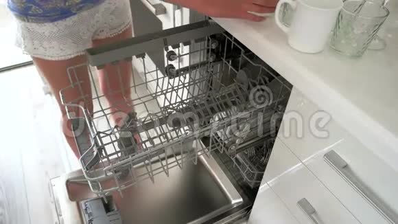 女人在家里把玻璃放进洗碗机里视频的预览图