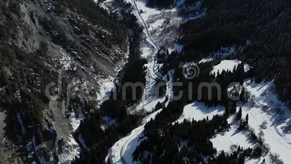 美丽的山路之间的树木环绕着巨大的山脉空中拍摄4k视频的预览图