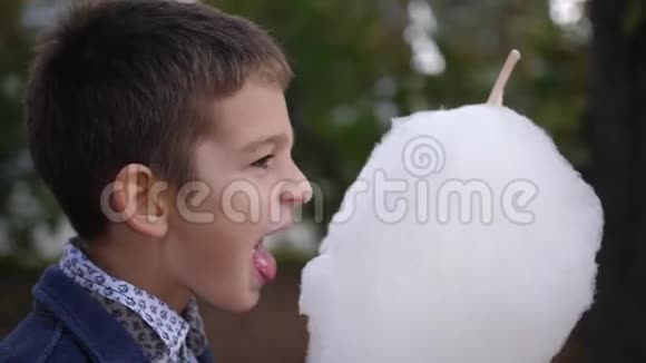 快乐的白种人少年吃棉花糖童年的梦想和回忆4k慢动作视频的预览图