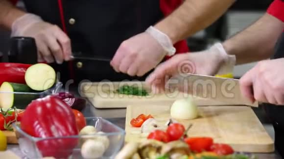 厨房里的一位厨师切洋葱和绿叶做菜视频的预览图