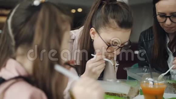 一家人一起在咖啡馆吃午饭母亲和两个女儿在咖啡馆里吃面条喝新鲜果汁视频的预览图
