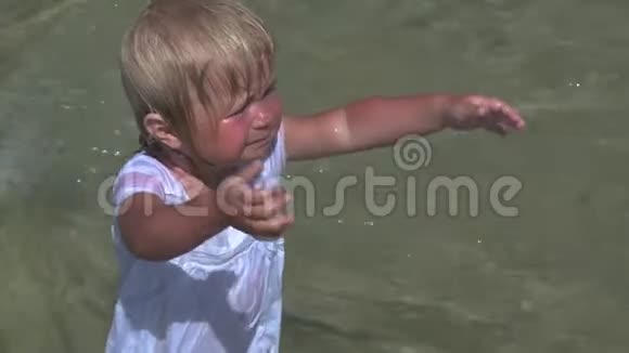 张开双臂站在水里哭着的婴儿视频的预览图
