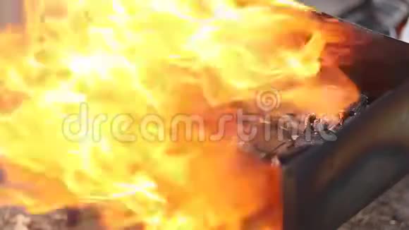 在自然界中烧烤炉上烧煤点火的特写视频的预览图