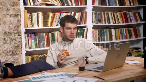 白种人男性的时间推移片段放松双腿坐在木桌上吃着美味的切片视频的预览图