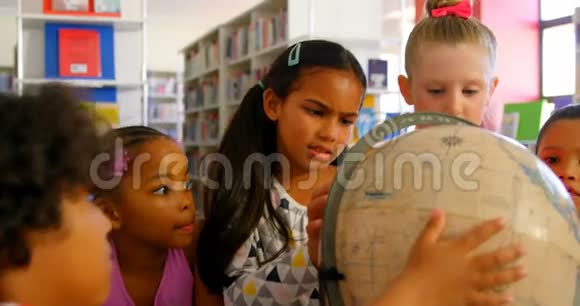 在学校图书馆里看地球仪的学生视频的预览图
