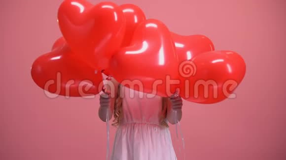 可爱的小女孩躲在心形气球后面情人节惊喜视频的预览图