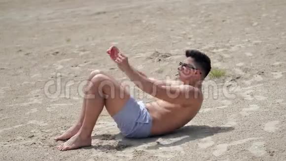 健身男在海滩上锻炼和做视频的预览图