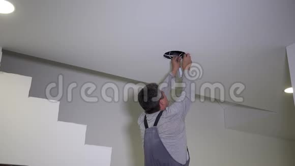 人将圆形LED灯板连接到石膏板天花板上视频的预览图