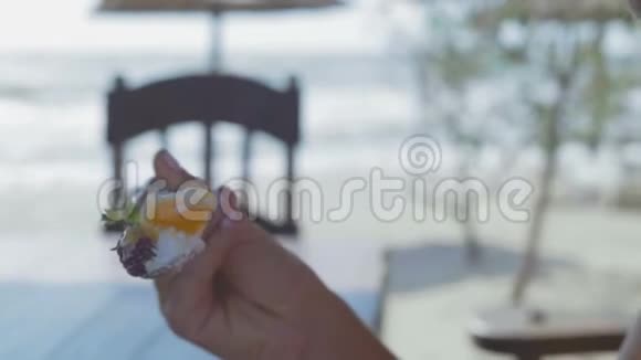 近景戴眼镜的美女在海边的咖啡馆里吃牛奶甜点和浆果视频的预览图