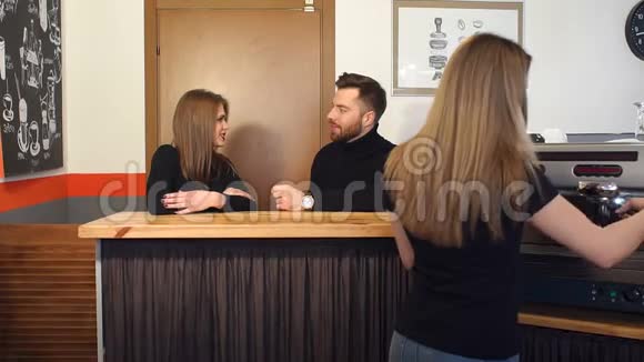 一个咖啡师女孩在一家现代化的咖啡店为年轻人准备芳香咖啡视频的预览图