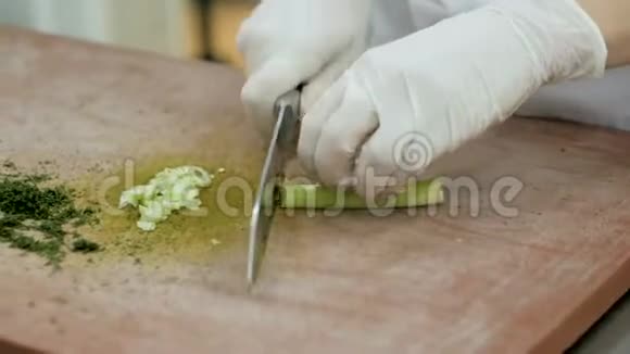 厨师把鲜芹菜棒切在木制砧板上视频的预览图