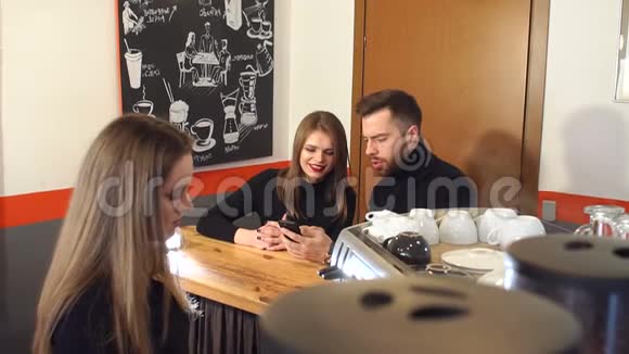 一个咖啡师女孩在一家现代化的咖啡店为年轻人准备芳香咖啡视频的预览图