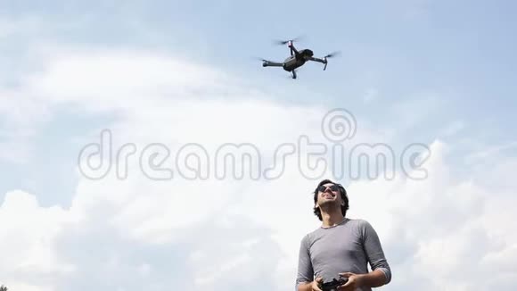 戴墨镜的年轻帅哥在看飞行无人机视频的预览图