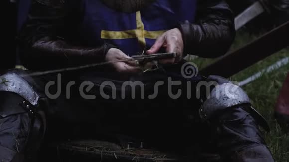 中世纪的士兵正在雨中用草擦剑关上视频的预览图