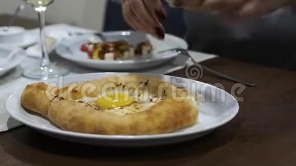 女人精心打扮的双手包裹着一块生鸡蛋里的卡查普里格鲁吉亚民族菜肴视频的预览图