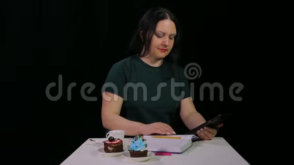 一个棕色头发的女孩在咖啡馆里和一块药片一起工作喝咖啡视频的预览图