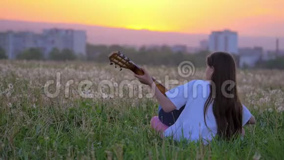 小女孩流行音乐家在城外练习吉他技巧在公园里弹吉他现场表演训练即兴表演视频的预览图