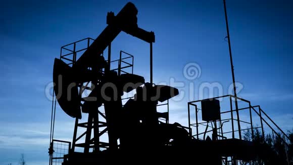 一个工业油泵千斤顶在现场抽油机剪影石油业务视频的预览图