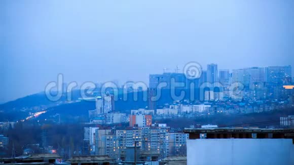 笼罩和雾气新建小区施工吊车在一座高山的边缘建造新城市视频的预览图