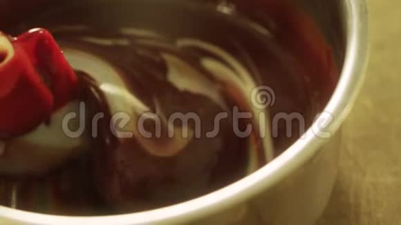 特写融化的黑白巧克力与抹刀在缓慢运动中混合视频的预览图