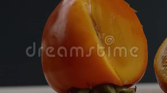 首先我们看到一个柿子然后视频从左到右移动我们看到一个橘子切成碎片黑色的背景视频的预览图