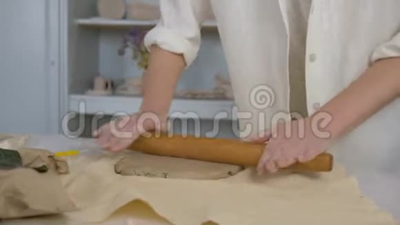 陶工师傅用擀面杖在制作陶瓷餐具时在桌上擀面视频的预览图