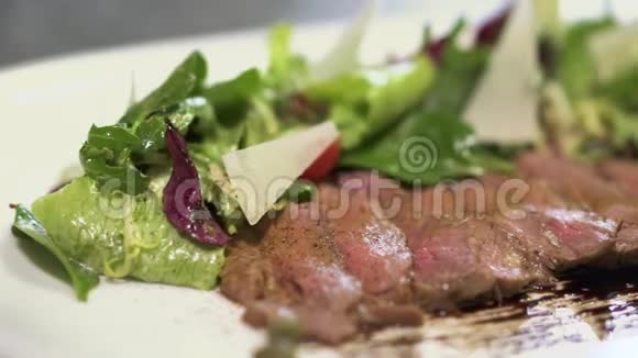 沙拉就在靠近盘子的生肉腌制块附近在现代餐厅供应食物视频的预览图