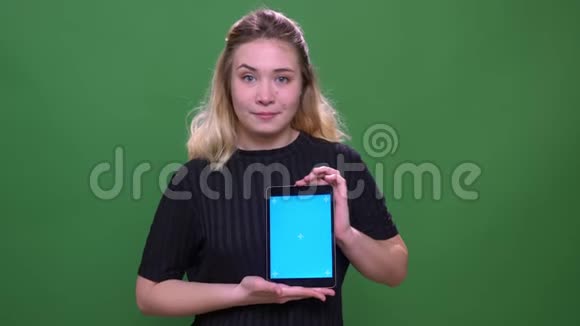 年轻漂亮的金发白种人女性使用平板电脑的特写肖像用蓝色屏幕拍摄视频的预览图