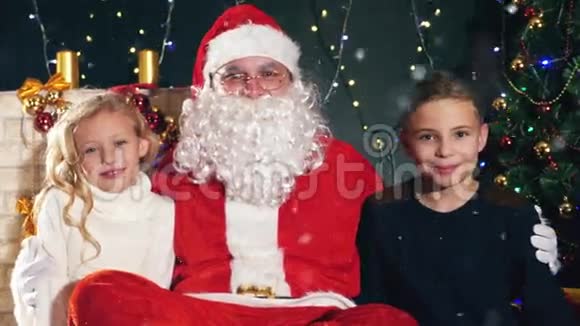 圣诞老人和孩子们在装饰好的圣诞树愿望清单视频的预览图