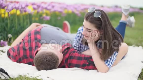 年轻夫妇躺在毯子上聊天视频的预览图