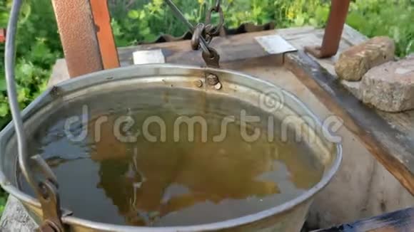 井里的脏水地球的生态学女人用水桶把链条滴到乡村井里打水视频的预览图