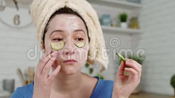 戴面具的女孩把黄瓜片放在眼睛下面视频的预览图