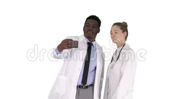 两位医生正在使用智能手机自拍并在白色背景上微笑视频的预览图