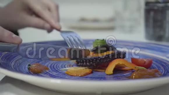 女人吃着美味可口的章鱼在蓝色盘子里烤着新鲜蔬菜关门视频的预览图