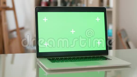 打开绿色屏幕和背景上的人的笔记本电脑的视差拍摄视频的预览图