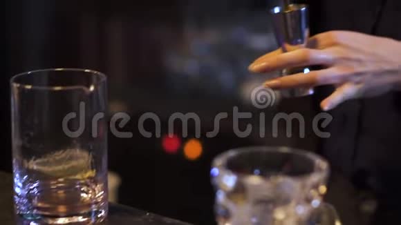 在酒吧里准备鸡尾酒的美甲女调酒师女孩用手在金属量杯里倒酒视频的预览图