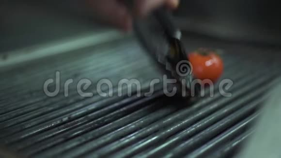 厨师手把蔬菜番茄茄子黄铃椒放在烤架上用金属钳关闭烹饪视频的预览图