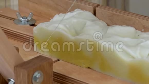 肥皂切割机的特写一根绳子从一块手工肥皂上剪下一块长方形的块视频的预览图