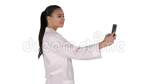 时尚的欧洲医生黑发在电话自拍而走在白色背景视频的预览图